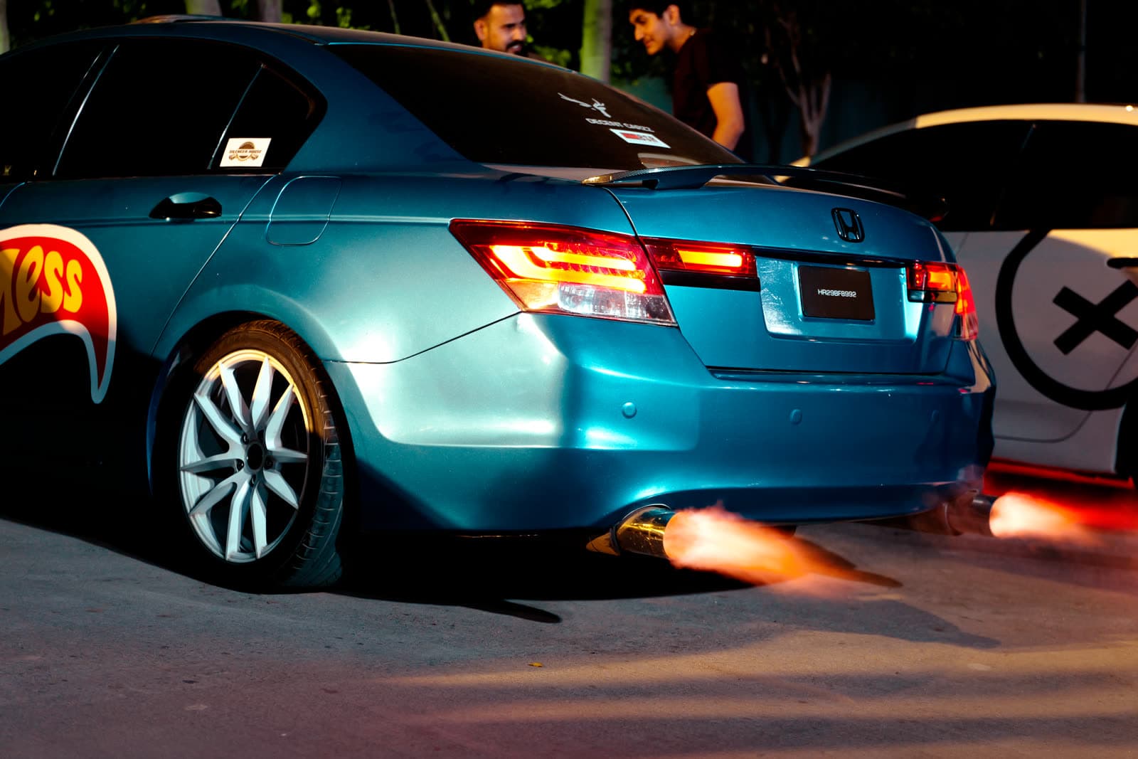 Blue Honda Accord shooting exhaust flames at a night meet