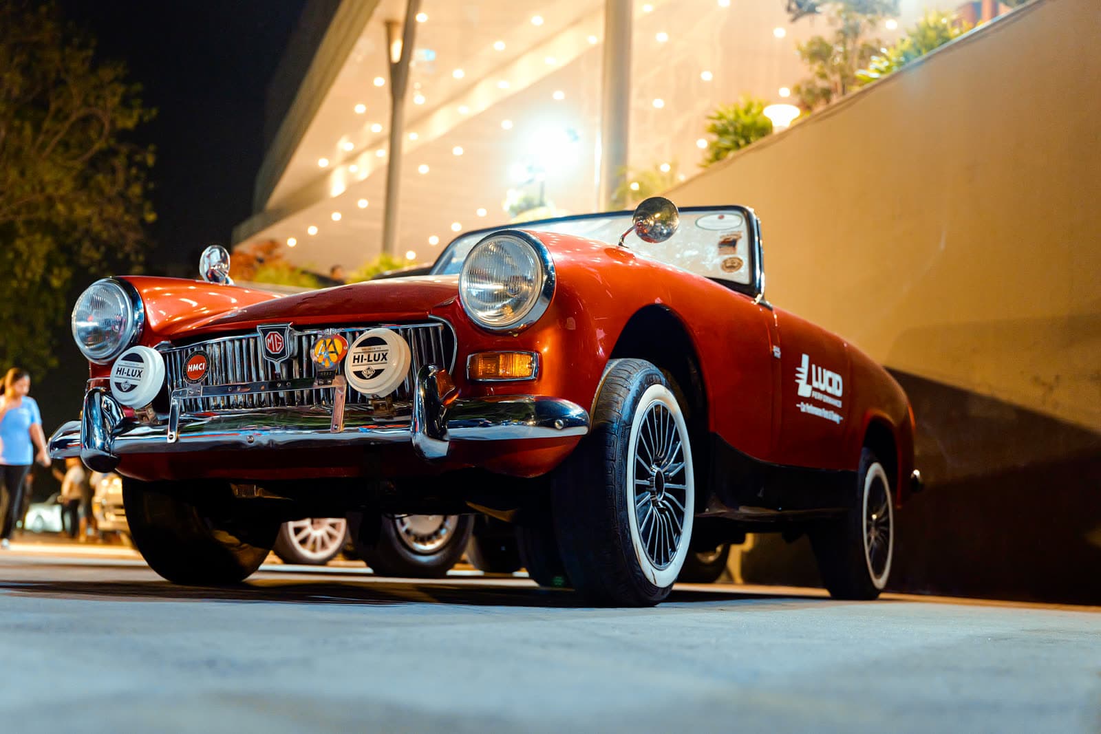 Vintage roadster with rally plates at an evening venue